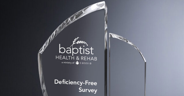 Crystal award engraved with “Baptist Health & Rehab” and “Deficiency-Free Survey” against a gray gradient background.